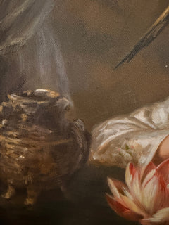 Close-up of a dark ceramic vessel, silk sleeve and lotus blossom