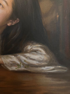 Close-up of dark hair, embroidered sleeve and painted background