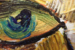 Close-up of a blue-green cat eye and raised palette-knife texture